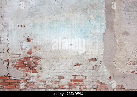 Old brick wall and ruined gray plaster with cracks texture background Stock Photo