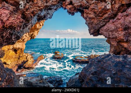 View from the inside of a stone grotto on the Mediterranean Sea off the coast of Sicily. Rocky shore of Milazzo cape, Sicily, Italy, Europe. Incredibl Stock Photo