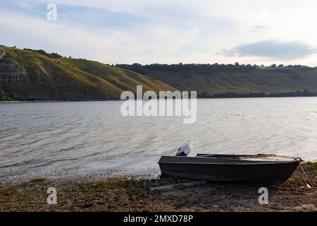 the boat stands on the bank of the river. Means of transportation on water. Stock Photo