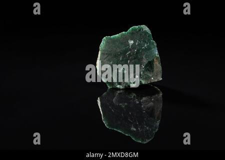 Uncut Green Moss Agate Gem Stone on Black Background with Reflection Stock Photo