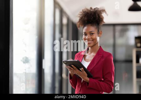 Woman on workplace taking information from digital tablet Stock Photo