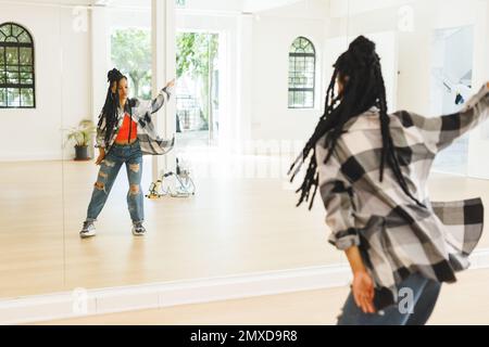Image of african american female hip hop dancer practicing at dance studio. Dance, rhythm, movement and training concept. Stock Photo