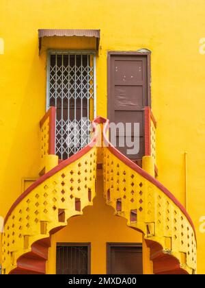 Colourful spiral staircase with metal gate and brown doors Stock Photo