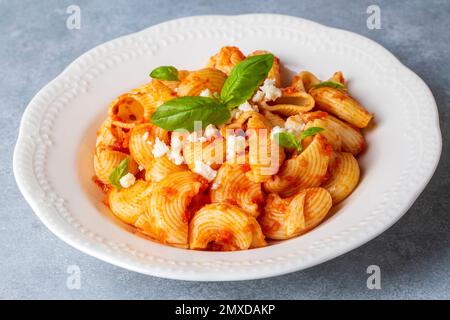 Tomato ravioli pasta or pipe rigate shaped pasta on the cheese Stock Photo