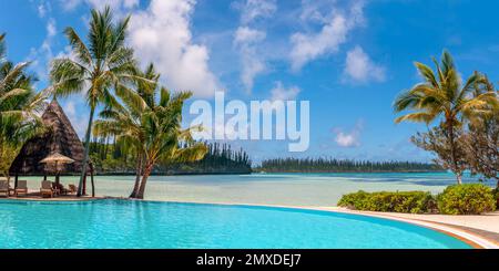 Infinity pool and palm trees, tropical beach, luxury travel resort in the Isle of Pines, New Caledonia Stock Photo