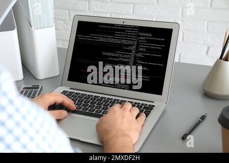 Professional programmer working with laptop in office, closeup Stock Photo