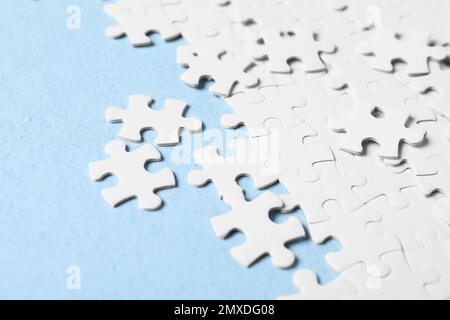 Blank white puzzle pieces on light blue background Stock Photo