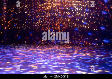 blurred rays of light on disco floor. orange violet blue neon searchlight lights. laser lines and lighting effect. night empty stage in studio with ne Stock Photo