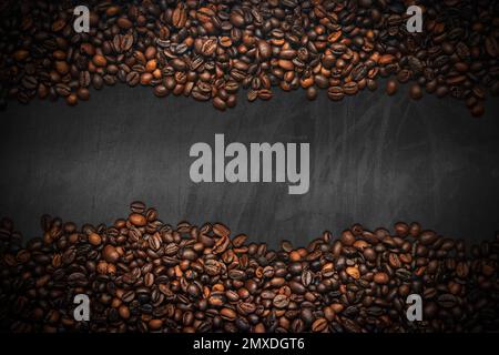 Large group of roasted coffee beans on an empty blackboard with copy space. Horizontal composition. Stock Photo
