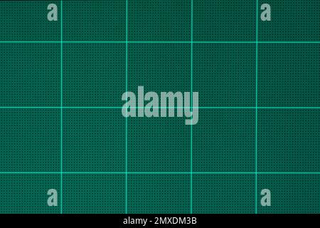 rubber green cutting mat sheet with grid guide line scale square shape background.idea for paper tools,school or graphic craft studio equipment backdr Stock Photo