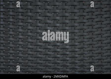 close up pattern of black plastic rattan modern furniture material  background.idea for weave wallpaper backdrop design. Stock Photo