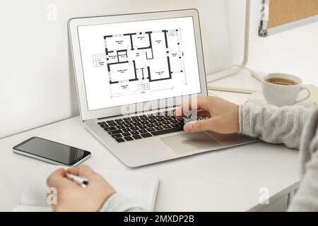 Architect making project of house on laptop in office, closeup Stock Photo