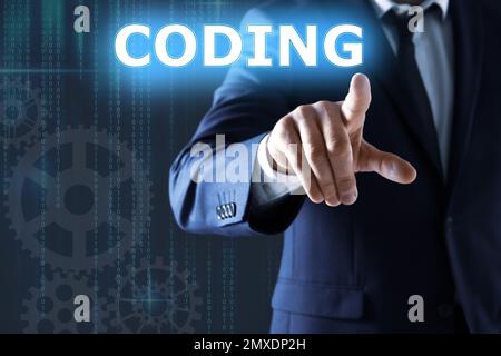Businessman pointing at word CODING on virtual screen, closeup Stock Photo
