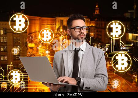 Fintech concept. Scheme with bitcoin symbols and businessman using laptop on cityscape background Stock Photo