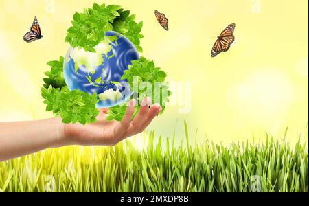 Man with illustration of Earth and recycling symbol in hand, closeup Stock Photo