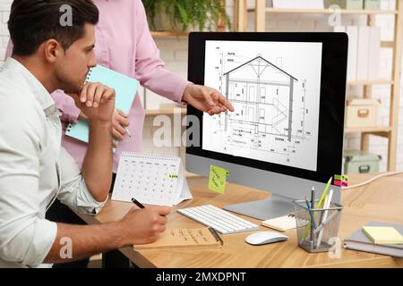 Architects making project of house on computer in office Stock Photo