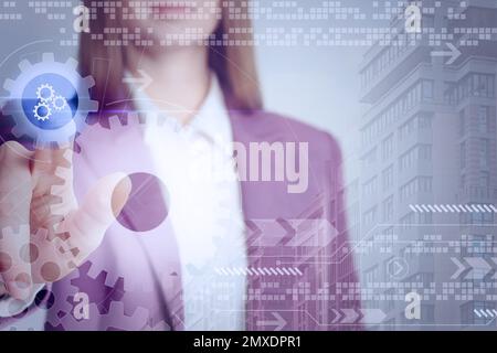 Businesswoman touching illustration of gear mechanism on virtual screen, closeup Stock Photo