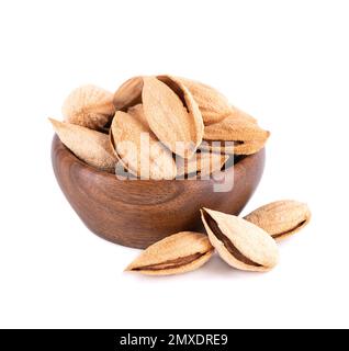 Mountain almonds in wooden bowl, isolated on white background. Uzbek wild almonds Stock Photo