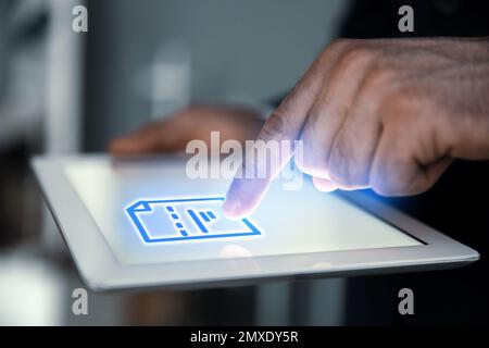 Man clicking on document icon using tablet, closeup Stock Photo