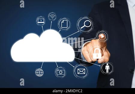 Cloud computing and storage concept. Man pointing at virtual icon on blue background, closeup Stock Photo