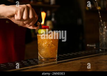 Bartender preparing fresh alcoholic cocktail at bar counter, closeup Stock Photo
