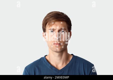 Facial recognition system. Young man with digital biometric grid on white background Stock Photo