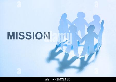 Paper human figures and text MISSION on light blue background Stock Photo