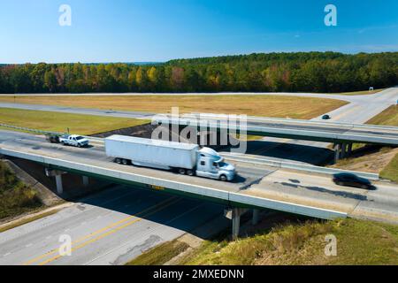 View from above of busy american highway with fast moving traffic between woods. Interstate transportation concept Stock Photo