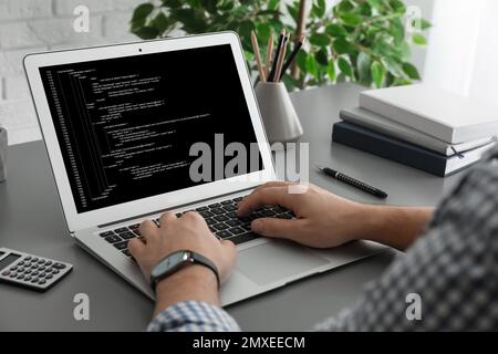 Professional programmer working with laptop in office, closeup Stock Photo