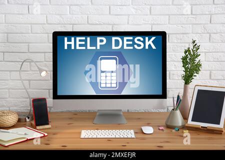 Modern computer and stationery on wooden table. Help desk service Stock Photo