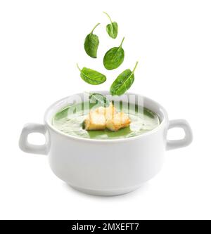 Fresh green spinach leaves falling into vegetable detox soup on white background Stock Photo