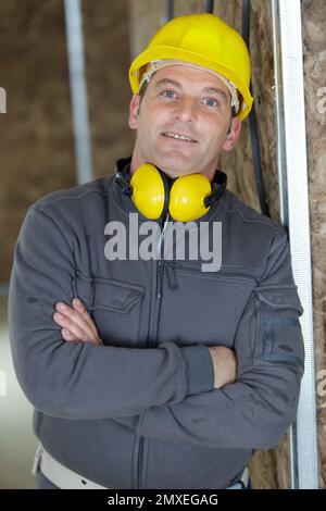 happy bearded  wearing hardhat with arms crossed Stock Photo