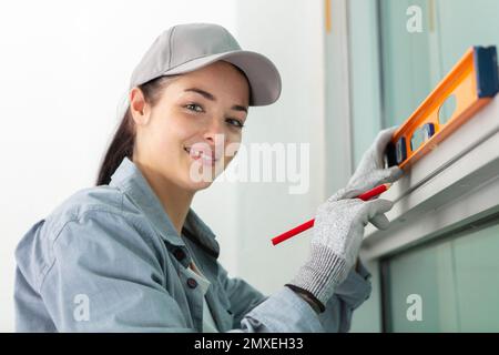 portait of a woman measuring window frame Stock Photo