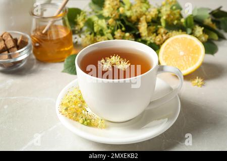 Cup of tea with linden blossom on light grey marble table Stock Photo