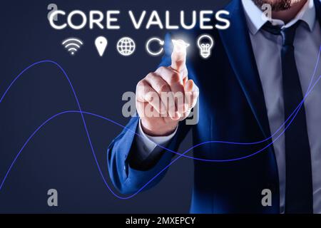 Core values concept. Businessman pointing at icon on virtual screen Stock Photo
