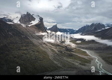 Southwest face of Mt. Thor, highest vertical cliff on Earth, on a cloudy September day. Hiking in wild, remote arctic valley of Akshayuk Pass, Baffin Stock Photo