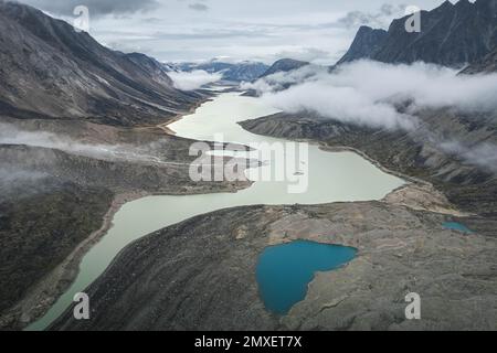 Southwest face of Mt. Thor, highest vertical cliff on Earth, on a cloudy September day. Hiking in wild, remote arctic valley of Akshayuk Pass, Baffin Stock Photo