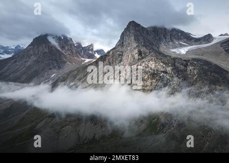 Southwest face of Mt. Thor, highest vertical cliff on Earth, on a cloudy September day. Hiking in wild, remote arctic valley of Akshayuk Pass, Baffin Stock Photo