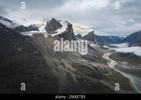 Southwest face of Mt. Thor, highest vertical cliff on Earth, on a cloudy September day. Hiking in wild, remote arctic valley of Akshayuk Pass, Baffin Stock Photo