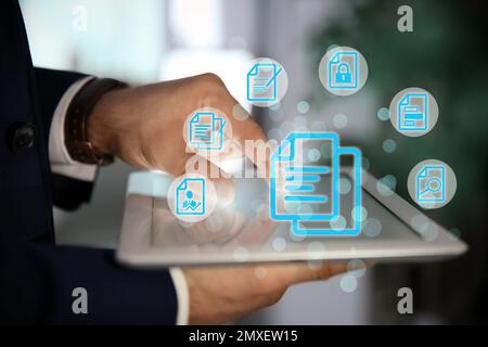 Man using tablet indoors and document icons, closeup Stock Photo
