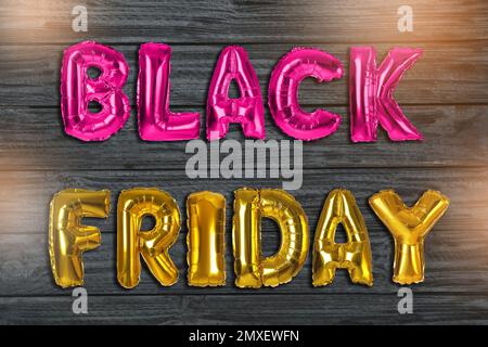 Phrase BLACK FRIDAY made of foil balloon letters on grey wooden background Stock Photo