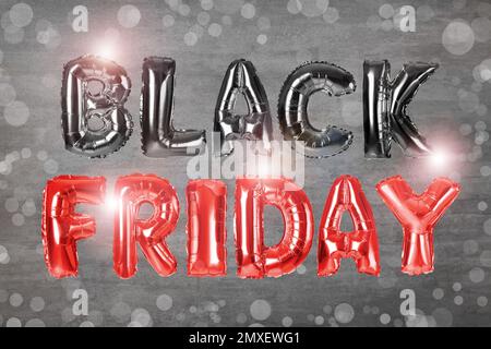 Phrase BLACK FRIDAY made of foil balloon letters on grey background Stock Photo