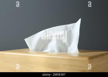 Wooden holder with paper tissues on dark background, closeup Stock Photo