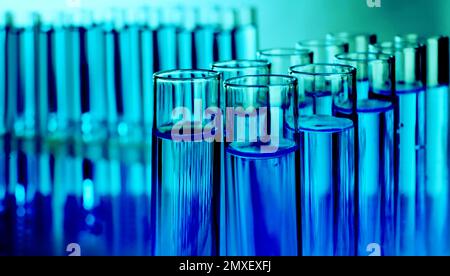 Test tubes with liquid against blurred background, closeup. Laboratory analysis Stock Photo