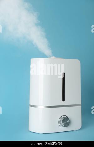 Modern air humidifier on light blue background Stock Photo - Alamy