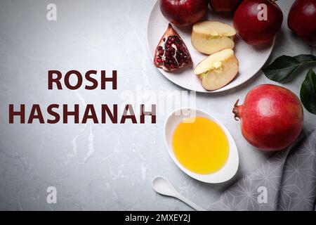 Honey, apples and pomegranate on marble table, flat lay. Rosh Hashanah holiday Stock Photo