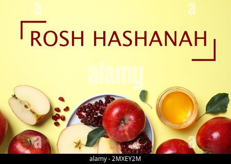 Honey, apples and pomegranate on yellow background, flat lay. Rosh Hashanah holiday Stock Photo