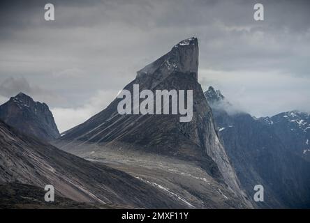 Southwest face of Mt. Thor, highest vertical cliff on Earth, on a cloudy September day. Hiking in wild, remote arctic valley of Akshayuk Pass, Baffin Stock Photo