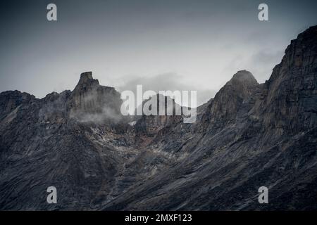 Southwest face of Mt. Thor, highest vertical cliff on Earth, on a cloudy September day. Hiking in wild, remote arctic valley of Akshayuk Pass, Baffin Stock Photo