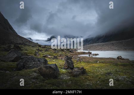 Southwest face of Mt. Thor, highest vertical cliff on Earth, on a cloudy September day. Hiking in wild, remote arctic valley of Akshayuk Pass, Baffin Stock Photo